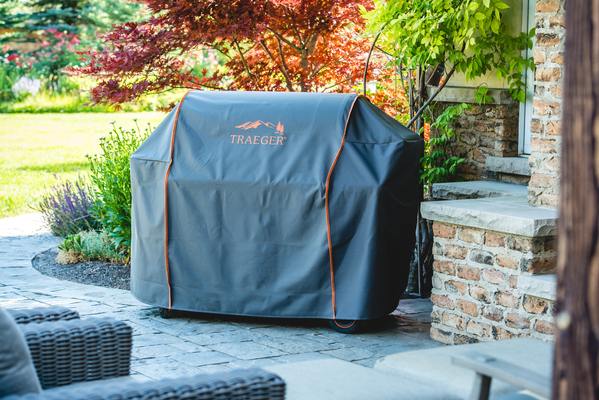 A Traeger wood pellet grill with a cover on it. 