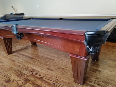 Pool table with hardwood floors underneath.