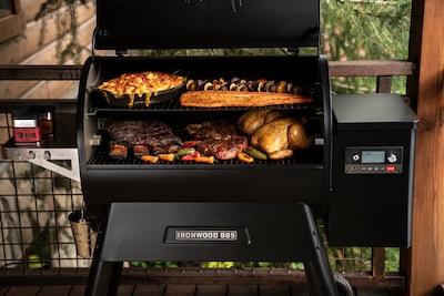 Traeger Ironwood 885 with a wide variety of food on the grill.