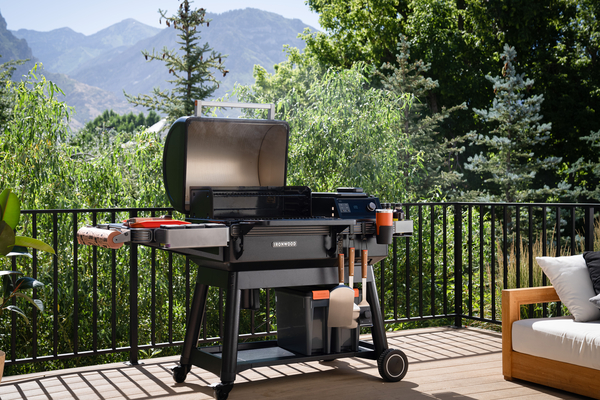 2023 Traeger Ironwood wood pellet grill on a patio deck with forest and mountains in the background.