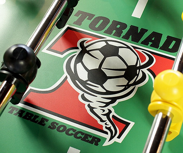 Tornado foosball table logo with soccer ball graphic on green playing surface and player rods